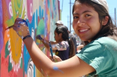 Grupo de adolescentes y jovenes realizan actividades juntos como pintar murales