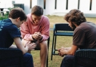 Tres jovenes reunidos orando