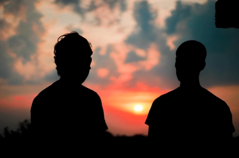 Dos hombres en silueta al amanecer