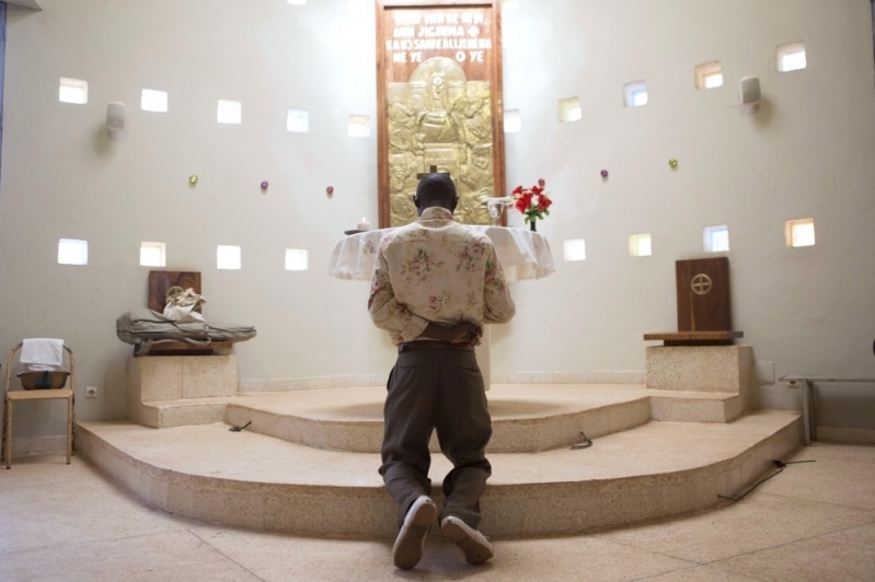 Hombre africano en oración en iglesia