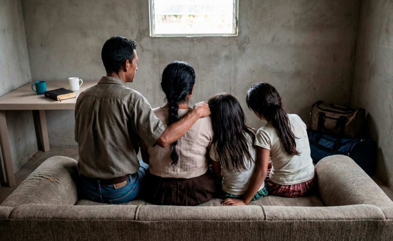 Familia cristiana pobre de espaldas