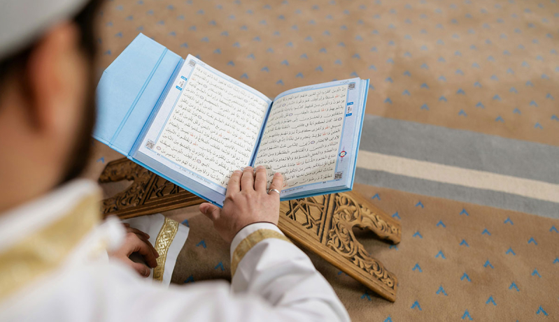 Hombre leyendo el Coran