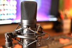 Micrófono negro frente a computadora en un estudio de sonido