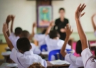 Niños en clase levantando la mano