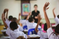 Niños en clase levantando la mano