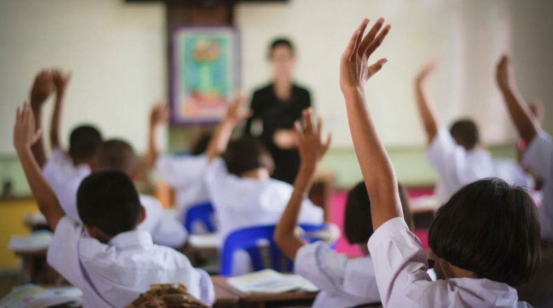 Niños en clase levantando la mano
